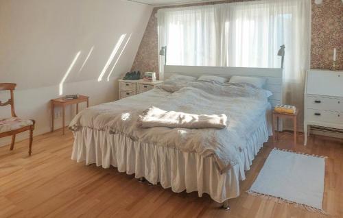 a bedroom with a large bed and a window at Nice Home In Ljusterö With Sauna in Norra Ljustero