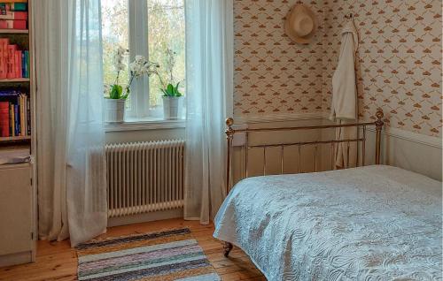 a bedroom with a bed sitting next to a window at Nice Home In Ljusterö With Sauna in Norra Ljustero