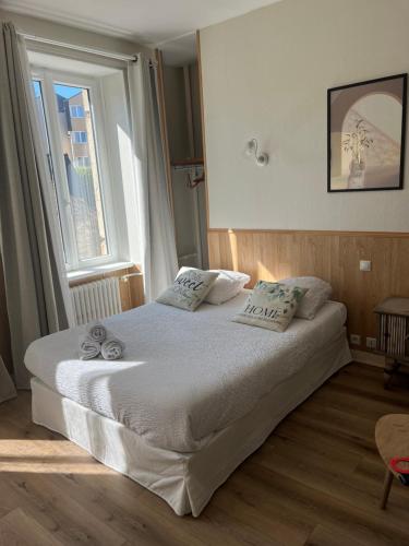 a bedroom with a white bed with a window at Hôtel Les Quais in Cherbourg en Cotentin