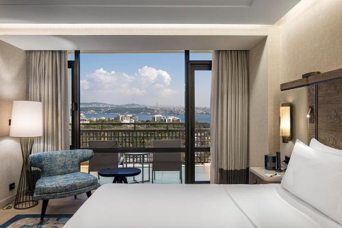 a bedroom with a bed and a balcony with a view at Hilton Istanbul Bosphorus in Istanbul