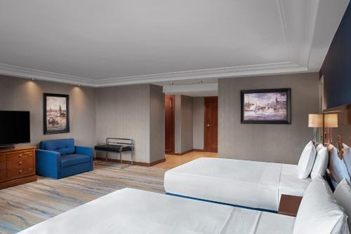 a bedroom with a large white bed and a blue couch at Hilton Istanbul Bosphorus in Istanbul