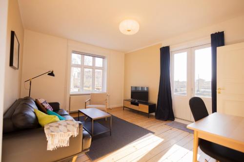 a living room with a couch and a tv at Central Lyngby Apartments in Kongens Lyngby