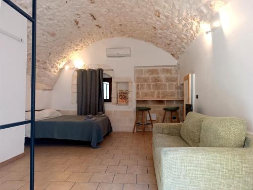a living room with a bed and a couch at Minuetto 73 in Ostuni