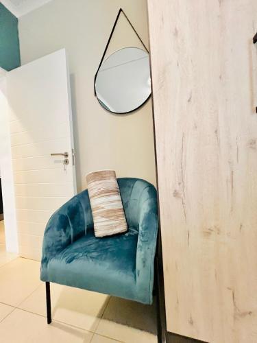 a blue chair in a room with a lamp at Exquisite Classy 1 bed in Midrand at 93 on New Lifestyle Estate in Midrand