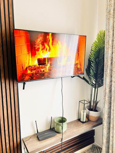 a tv hanging on a wall with a fireplace at Exquisite Classy 1 bed in Midrand at 93 on New Lifestyle Estate in Midrand