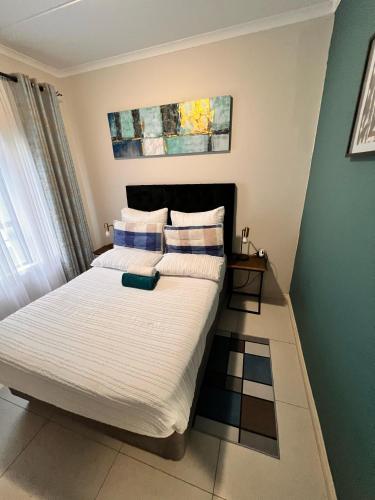 a bedroom with two beds with white and blue pillows at Exquisite Classy 1 bed in Midrand at 93 on New Lifestyle Estate in Midrand