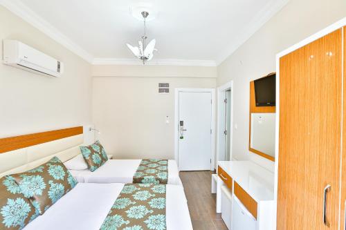a hotel room with a bed and a tv at Hotel Kayahan in Kas
