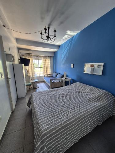 a blue bedroom with a bed and a blue wall at Costa de Tigre, habitaciones in Tigre