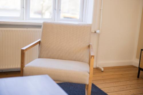 a chair sitting in a room with a window at Central Lyngby Apartments in Kongens Lyngby