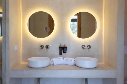 two sinks in a bathroom with two mirrors at Hotel Serawa Moraira in Moraira