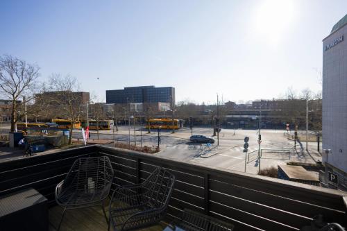 a balcony with chairs and a parking lot with buses at Central Lyngby Apartments in Kongens Lyngby