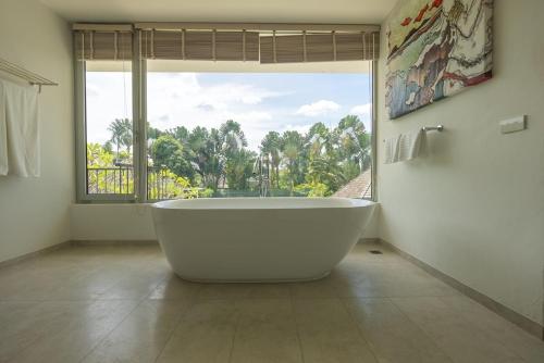 a large white tub in a bathroom with a large window at Top Pool Villa Layan Estate Laguna Bangtao in Layan Beach