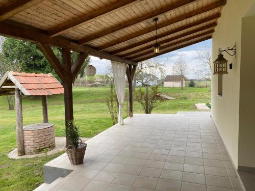an outdoor patio with a wooden pergola at Villa Lano in Kispeterd