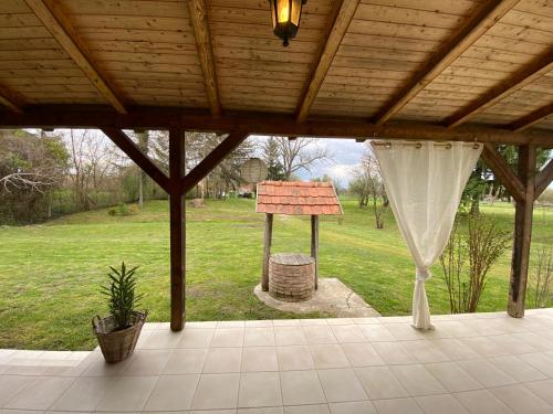 a covered patio with a wooden roof and a bbq grill at Villa Lano in Kispeterd