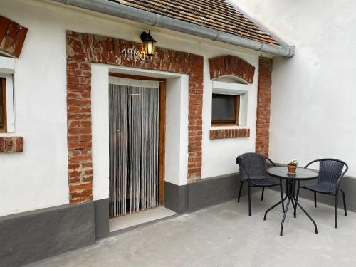 a patio with a table and chairs next to a building at Villa Lano in Kispeterd