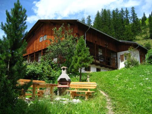 a wooden building with a bench in front of it at Ciasa Raut in La Valle