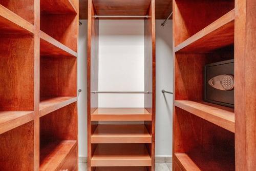 a closet with wooden shelves and a tv at Exclusive Beach Residence! with Private Pool in Playa del Carmen