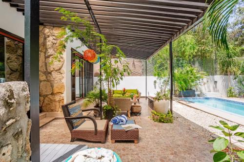 an outdoor patio with chairs and a swimming pool at Exclusive Beach Residence! with Private Pool in Playa del Carmen