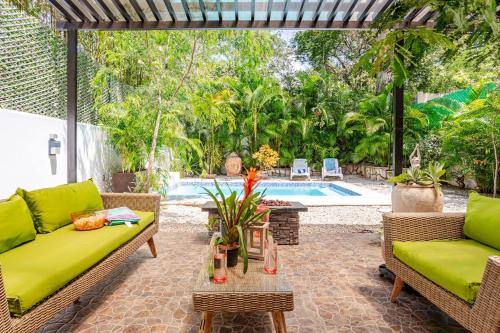 a patio with two couches and a table and a pool at Exclusive Beach Residence! with Private Pool in Playa del Carmen