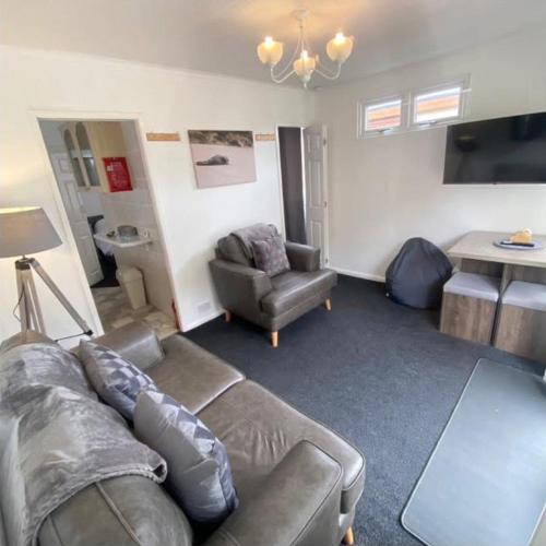 a living room with a couch and a table at Seaside Chalet Mablethorpe in Mablethorpe