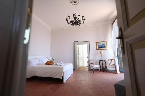 a bedroom with a white bed and a chandelier at La Tua Terrazza in Costiera in Albori