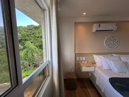 a bedroom with a bed and a large window at Bela Hospedagem - Puerto Ventura, frente mar e ao lado do food park in João Pessoa