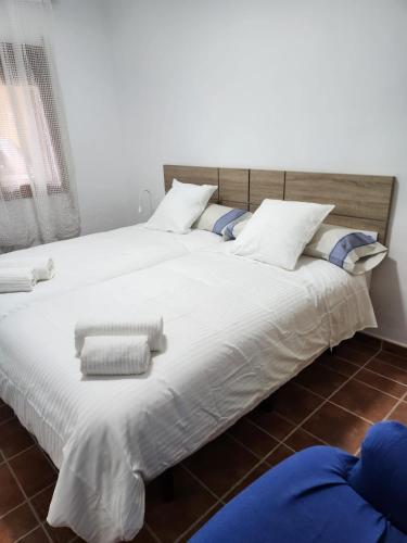 a large bed with white sheets and pillows at La Casona de Piedra in Cartagena