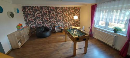 a room with a ping pong table in front of a wall at Domek Chrzanówka in Kudowa-Zdrój