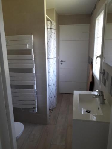 une salle de bain avec un lavabo et des toilettes et une porte dans l'établissement Chambre Nature, à Saint-Justin
