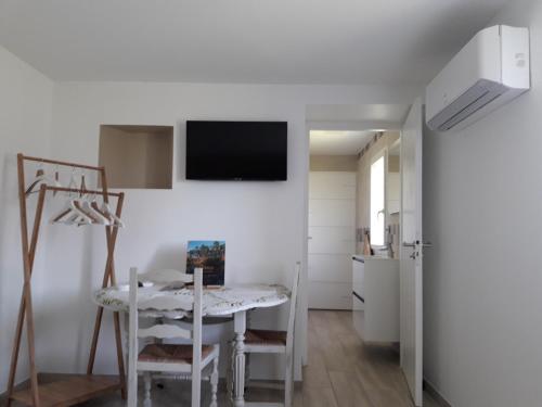 d'une salle à manger avec une table et une télévision murale. dans l'établissement Chambre Nature, à Saint-Justin