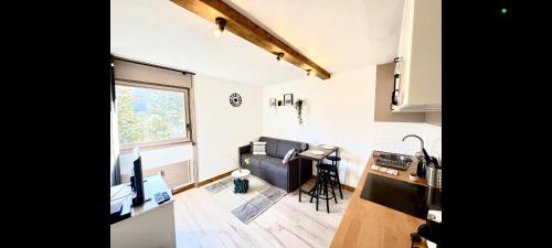 a living room with a couch and a kitchen at Charmant appartement à Saint-Gervais-les-Bains, idéal pour vos vacances à la montagne in Saint-Gervais-les-Bains