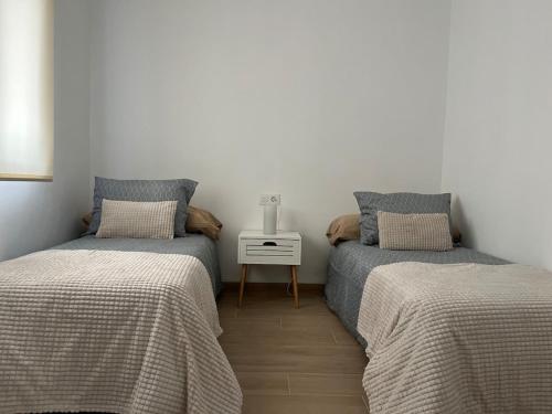 2 letti singoli in una camera con tavolo di La casa del abuelo José a Las Eras