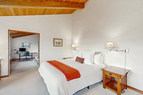 a bedroom with a white bed and a desk at Blue Heron in Sea Ranch