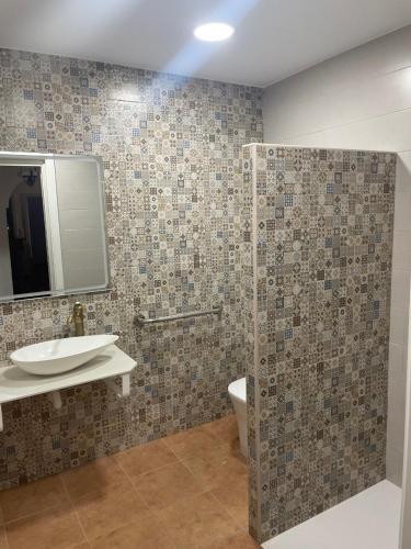 a bathroom with a sink and a toilet and a mirror at La Casona de Piedra in Cartagena