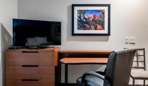a desk with a television and a desk with a chair at My Place Hotel-Colorado Springs,CO in Colorado Springs