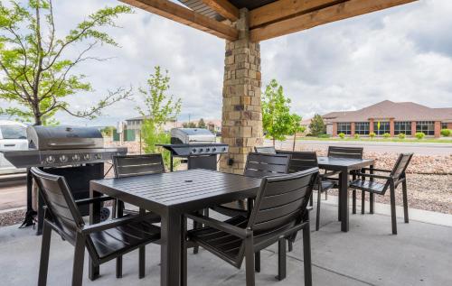 a patio with tables and chairs and a grill at My Place Hotel-Colorado Springs,CO in Colorado Springs
