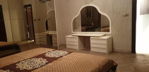 a bedroom with two beds and a large mirror at Al Wahda Private Couples Room in Abu Dhabi