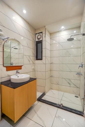 a bathroom with a sink and a glass shower at Hotel Highway Greens Near VR Punjab Mall Airport Road Mohali Chandigarh in Mohali