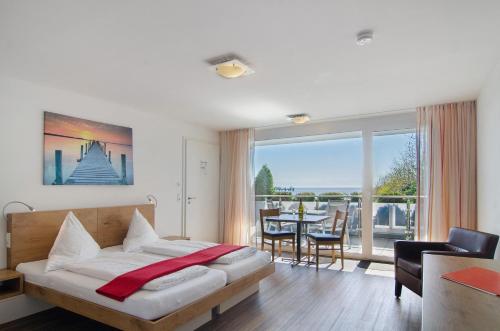 a bedroom with a bed and a table with chairs at Gästehaus D i c k r e i t e r in Immenstaad am Bodensee