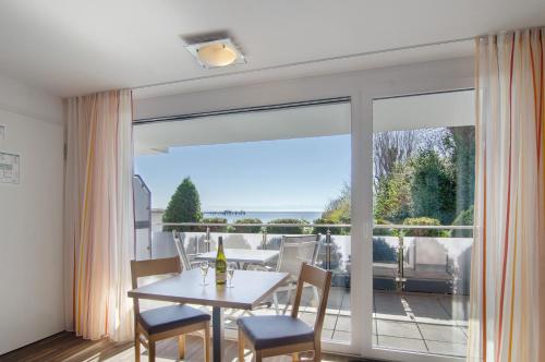 a dining room with a table and chairs and a large window at Gästehaus D i c k r e i t e r in Immenstaad am Bodensee