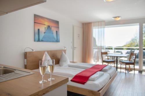 a hotel room with a bed with two glasses of wine at Gästehaus D i c k r e i t e r in Immenstaad am Bodensee