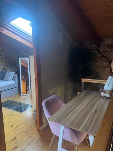 a wooden table and a chair in a room at El Refugio I de Verdiago in Verdiago