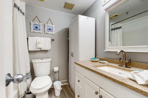 a bathroom with a toilet and a sink and a mirror at Pirates Bay B315 - Bayfront Beauty in Fort Walton Beach
