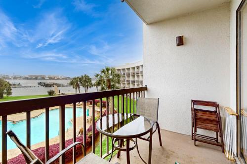 a balcony with a table and a view of the pool at Pirates Bay B315 - Bayfront Beauty in Fort Walton Beach