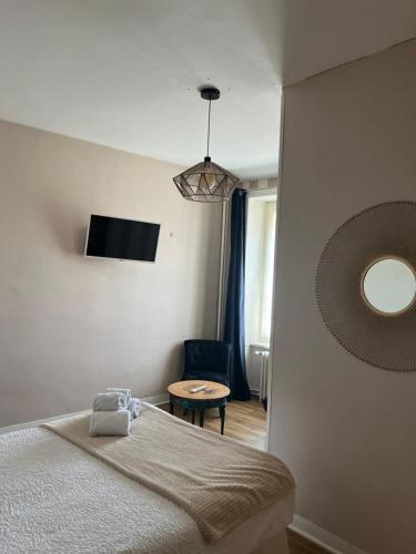 a bedroom with a bed and a chair and a mirror at Hôtel Les Quais in Cherbourg en Cotentin