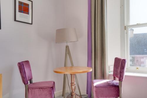 a room with a table and two purple chairs at The County Hotel - Self Check-In, Ultra Fast WI-FI, Free Parking, Central Location in Selkirk