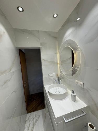a white bathroom with a sink and a mirror at Casa Trussardi in Pirovac