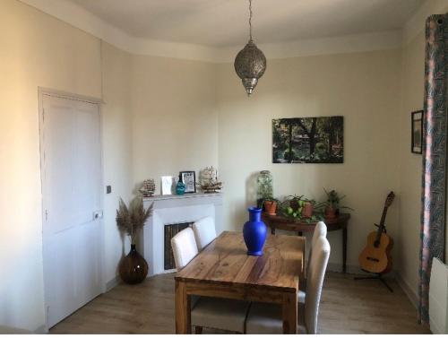 d'une salle à manger avec une table en bois et un vase bleu. dans l'établissement Avignon T2 bis 54 m2 intra-muros 2ème ETAGE SANS ASCENSEUR, à Avignon