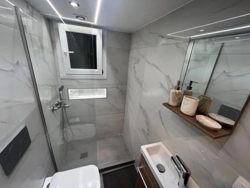 a bathroom with a shower and a sink at Διαμέρισμα δίπλα από την θάλασσα in Athens
