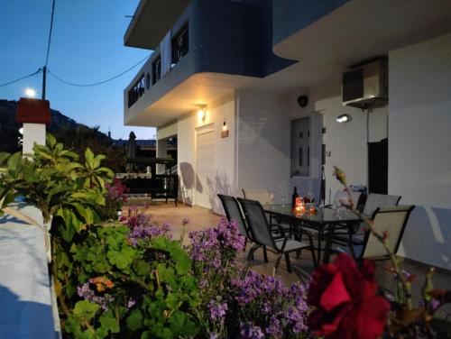 a balcony of a house with a table and some flowers at Tharreni House, Pilona Village in vlicha